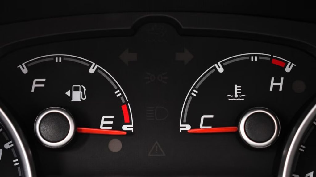 Detailed view of a car's fuel and temperature gauges on dashboard.